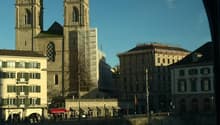 View of a city with a large church, buildings, and a river