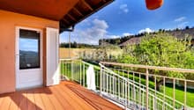 Balcon en bois offrant une vue panoramique sur la nature environnante.