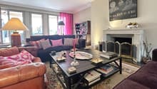 Fireplace, coffee table, sofa, rug, bookcase, lamp, large windows