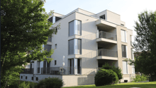 modern apartment building, white exterior, multiple balconies, green surroundings