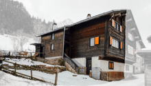 2 story wooden house, slanted roof, multiple windows, wooden fences