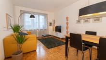 Wooden floor, yellow sofa, television, side table, dining table, floor lamp