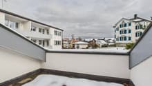white concrete building, covered balcony, covered in snow