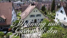House with garden, multiple houses in the background, trees, plants, and flowers