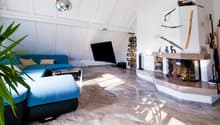 living room with fireplace, blue sofa, coffee table, TV, floor lamp, wooden floor