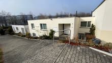 modern apartment building, white exterior, brick driveway, fenced garden, handrail on steps