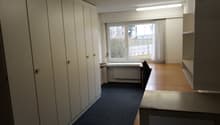 empty room, white cabinets, desk, chair, window, radiator, blue carpet
