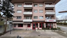 apartment building, balconies on each floor, awning above entrance, Zahnarzt text below top balcony
