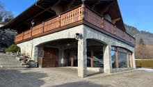 Rustic mountain house with wooden balcony, brick and stone construction, double entrance, security camera, brick driveway