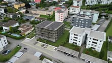 multi-storey apartment buildings, solar panels, swimming pool, several cars parked in underground parking
