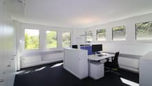 modern office room, white walls, black carpet, large windows, desk, computer, chair