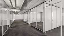 Glass walls and floor, carpeted flooring, silver pipes on ceiling, lights