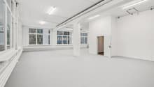 Empty room with white walls, white floor, large windows, white ceiling, white door, white pillars