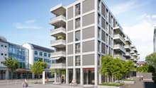 Modern apartment building with multiple balconies, glass windows, and a ground floor with commercial space.