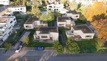 modern architecture with solar panels, balconies, swimming pools, parking area, and lush green surroundings