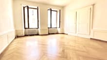 empty room, wooden floors, white walls, three windows, white doors, two white radiators