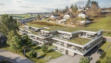 residential building with multiple units, green roof, multiple balconies, raised ground floor, paved road, parking area