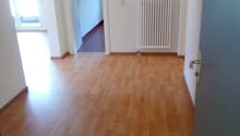 wooden floor, white walls, white radiator, glass window, doorway, hallway