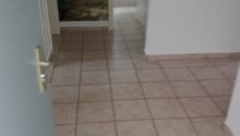 Empty hallway with tiled floor, white walls, open door, and a mural on the wall.