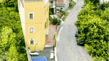 yellow house, swimming pool, road, cars, trees