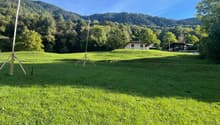 hill, green lawn, two houses at the back, clear view of the mountains