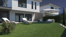 modern 2 story house, large white patio with fake grass, 2 loungers, 1 couch, 1 umbrella, steps leading up to patio