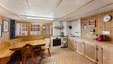 kitchen with dining area, wooden furniture, white appliances, tiled floor, wooden walls, large windows
