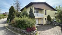 2 story house, yellow exterior, white garage, balcony, driveway, garden