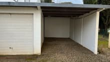 Empty garage with gravel floor and metal roofing