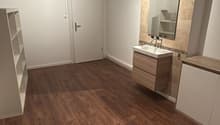empty room, wooden floors, white walls, ceiling lamp, mirror, sink, cabinets