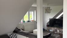 White couch, white ottoman, lamps, tv, wooden floor, window, wooden shelves, boxes