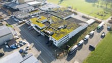 multi-storey building, green rooftop, multiple parking spots, various vehicles