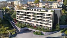 Multi-story building with multiple balconies, raised ground floor, underground garage