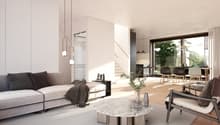 living room with white walls, grey couch, white center table, open to dining room with windows and view to outside