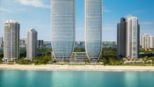 Two high-rise buildings, modern design, glass facades, located on the beach, surrounded by other buildings and greenery