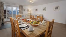 dining table, wooden chairs, large windows, view of mountains, breakfast set, couch, lamp