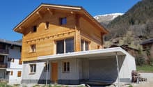 New construction house made of wood and concrete, surrounded by nature with mountains in the background, balcony, garage