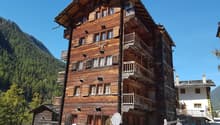 wooden building, multiple balconies, multiple windows, mountains in the background