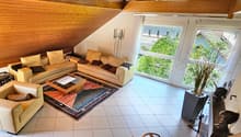 tiled floor, beige leather sofas, L-shaped sofa, wooden ceiling, coffee table, wooden rug, lamps, large windows, indoor plants, fireplace