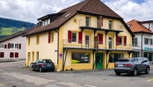 yellow house, brown roof, red shutters, balcony, parking place