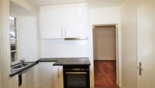 modern kitchen, white cabinets, black countertops, stainless steel appliances, sink, dishwasher, oven