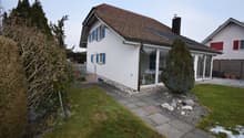 modern house, white wall, blue shutters, glass wall, solar panels on roof, paved pathway
