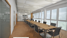 conference room, long table, chairs, large windows, overhead lights