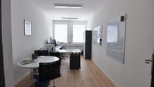empty office with tables, chairs, computer, whiteboards, frames, wooden floor