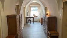 long hallway, vaulted ceiling, desk, wooden cabinet, small stool
