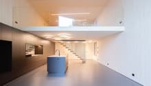modern kitchen with island, glass railing, open staircase, wooden ceiling, white walls