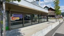 Commercial building with glass facade, sign reading 'Gewerbefläche gesucht?'
