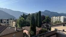 Balcony overlooking cityscape with mountains in the background
