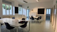 empty room, white walls, white tables, black chairs, windows, radiators, cabinets, blackboards