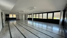 Large open space with marble flooring, floor-to-ceiling windows, and recessed lighting. The room appears to be a multipurpose space, potentially used for events or activities.